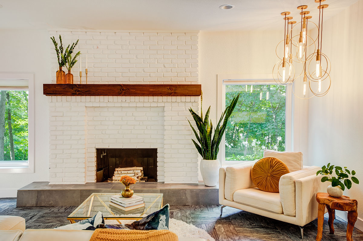 Learn more about Sara Svehla at our website: sarasvehla.com This image showcases a basement hearth renovation with pendant lighting over an upholstered arm chair.