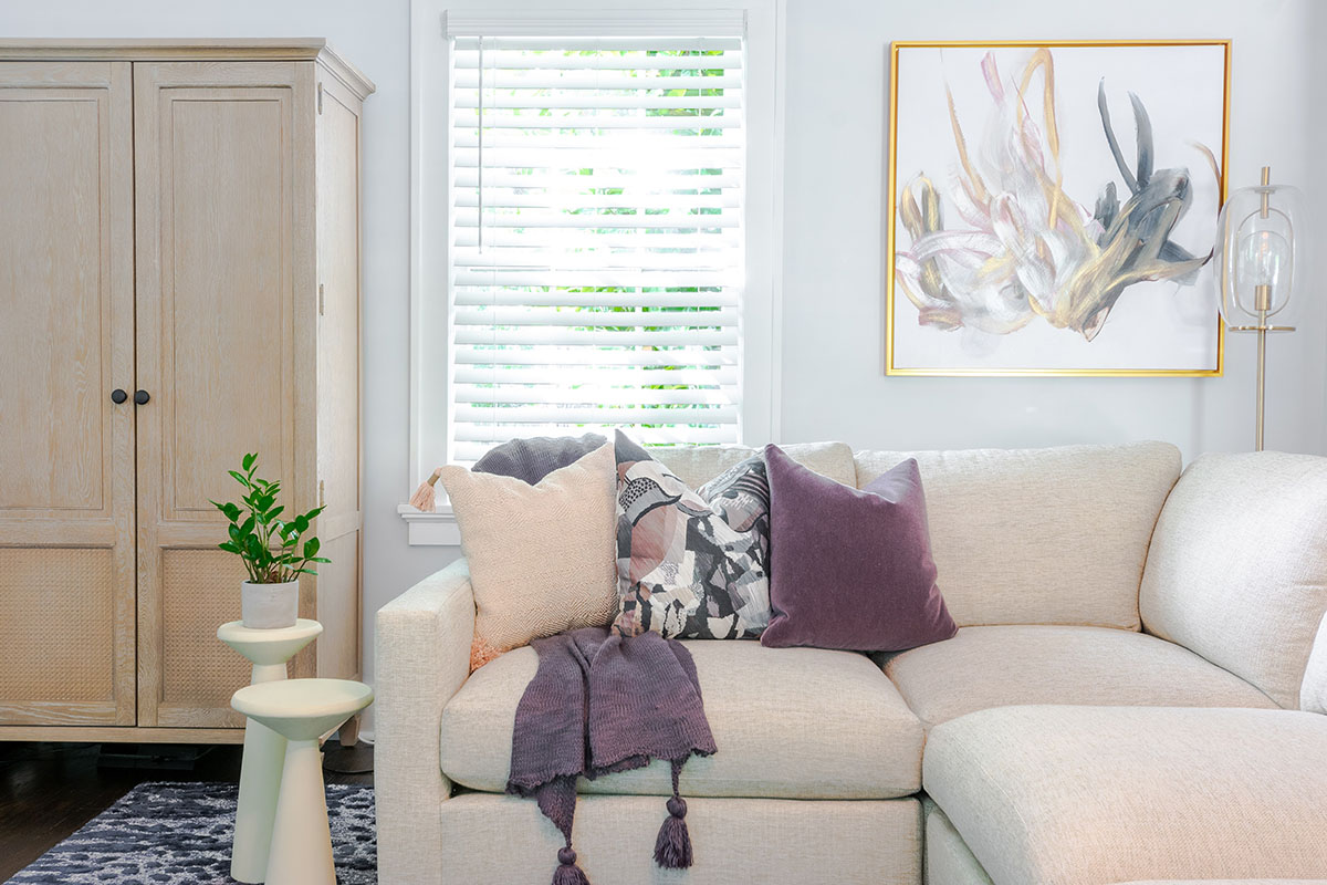 historic home renovation family room with a cream sectional and a geometric area rug, in front of the stair to the second level.