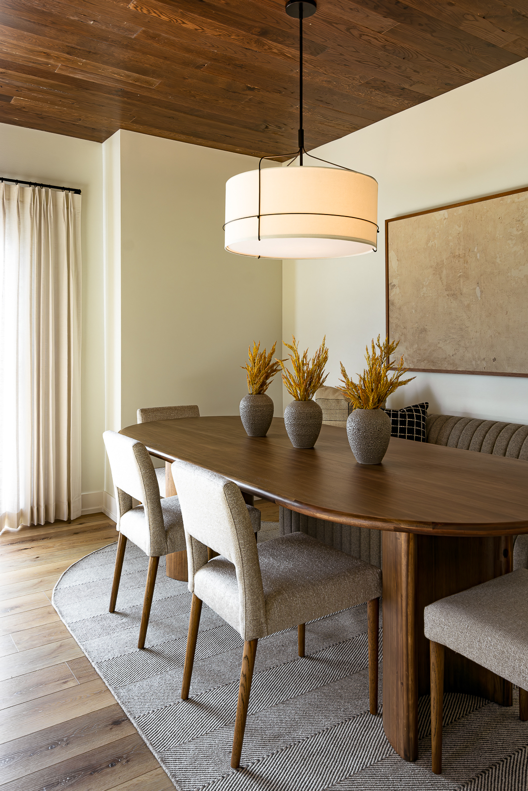 lower level dining space with a custom settee and four dining chairs atop a custom oval rug at the Haven custom home project.