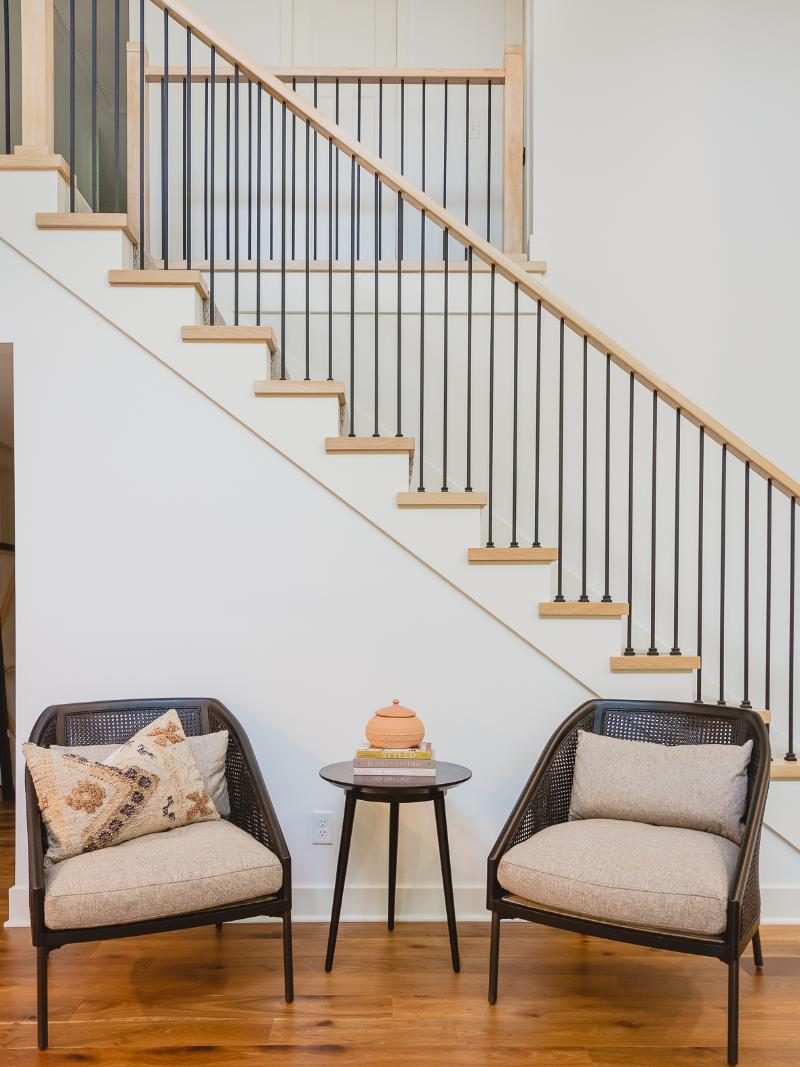 Simple staircase with two dark wicker chairs.