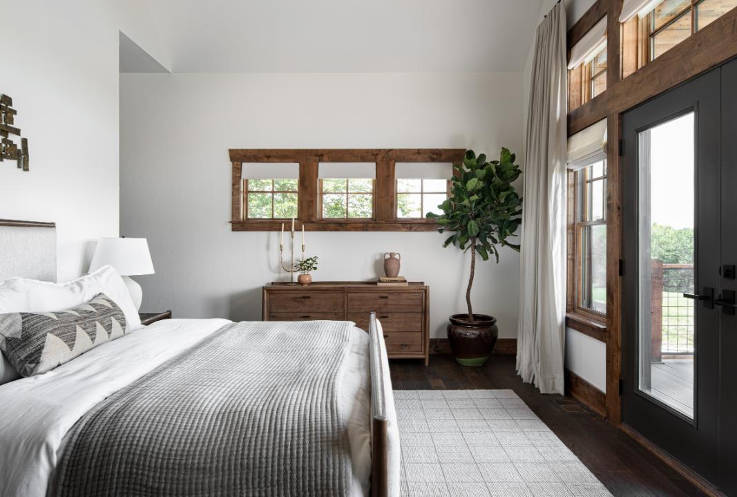 Primary Bedroom Suite with fiddle leaf fig tree and custom window treatments, with attached patio.